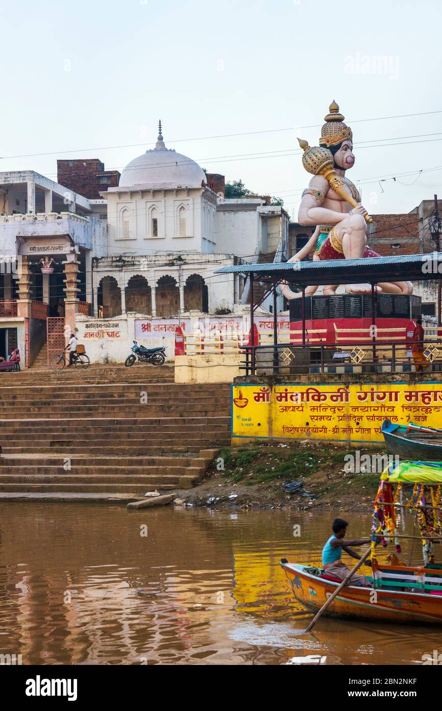 Chitrakoot, Madhya Pradesh, India : A boatman rows past a large Hanuman statue by the Mandakini river where during their exile period Lord Rama, Laksh Stock Photo