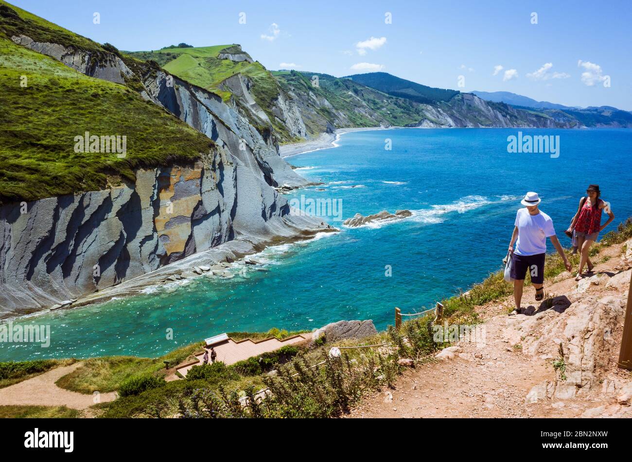 Zumaia, Gipuzkoa, Basque Country, Spain - July 15th, 2019 : Tourists hike atop the cliff made of flysch rock. Stock Photo