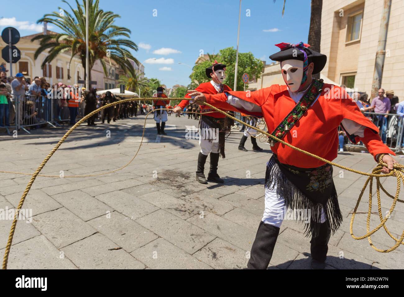 Sardinia festival, a man dressed in the traditional folk dress of a Issohadore prepares to lasso a spectator at the Cavalcata festival in Sassari. Stock Photo