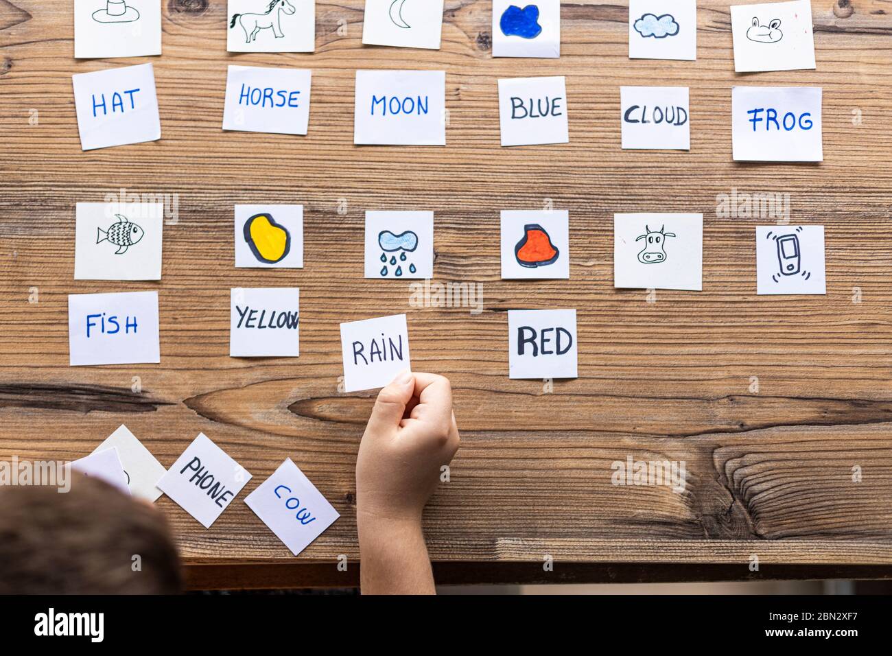 Little kid playing with cards of words and pictures. Time to learn ...