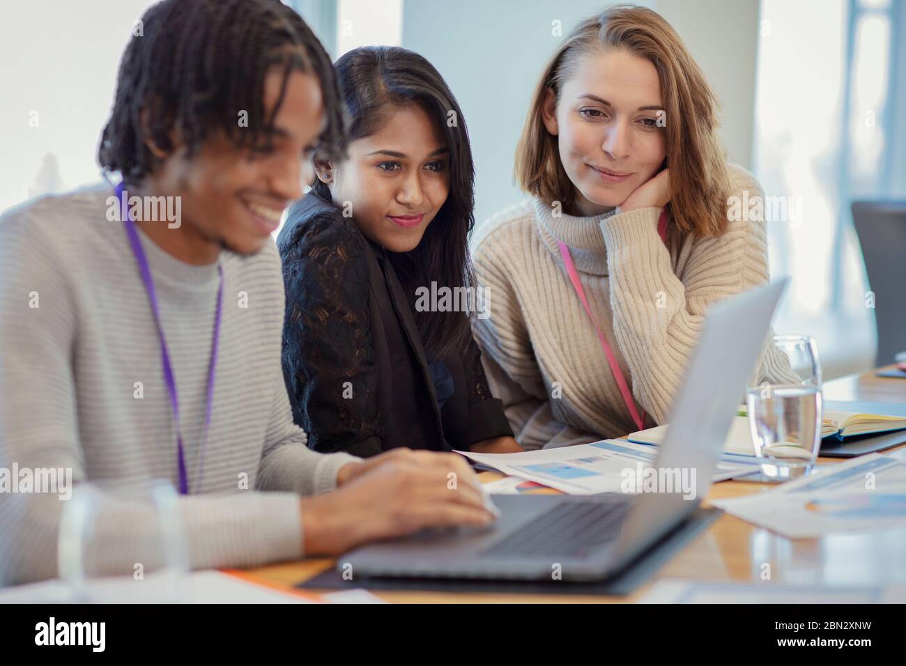 Business people using laptop in meeting Stock Photo