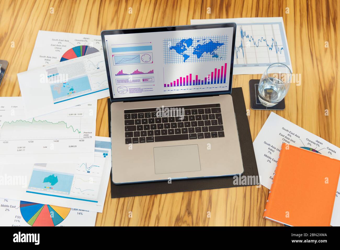 Charts and graphs on laptop and paperwork Stock Photo