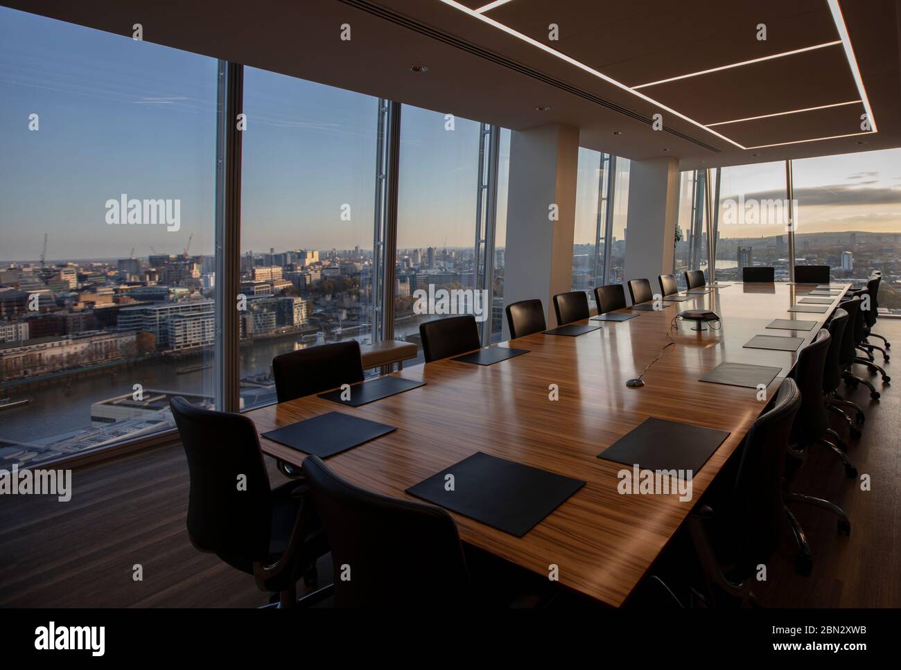 Modern highrise conference room table overlooking city Stock Photo