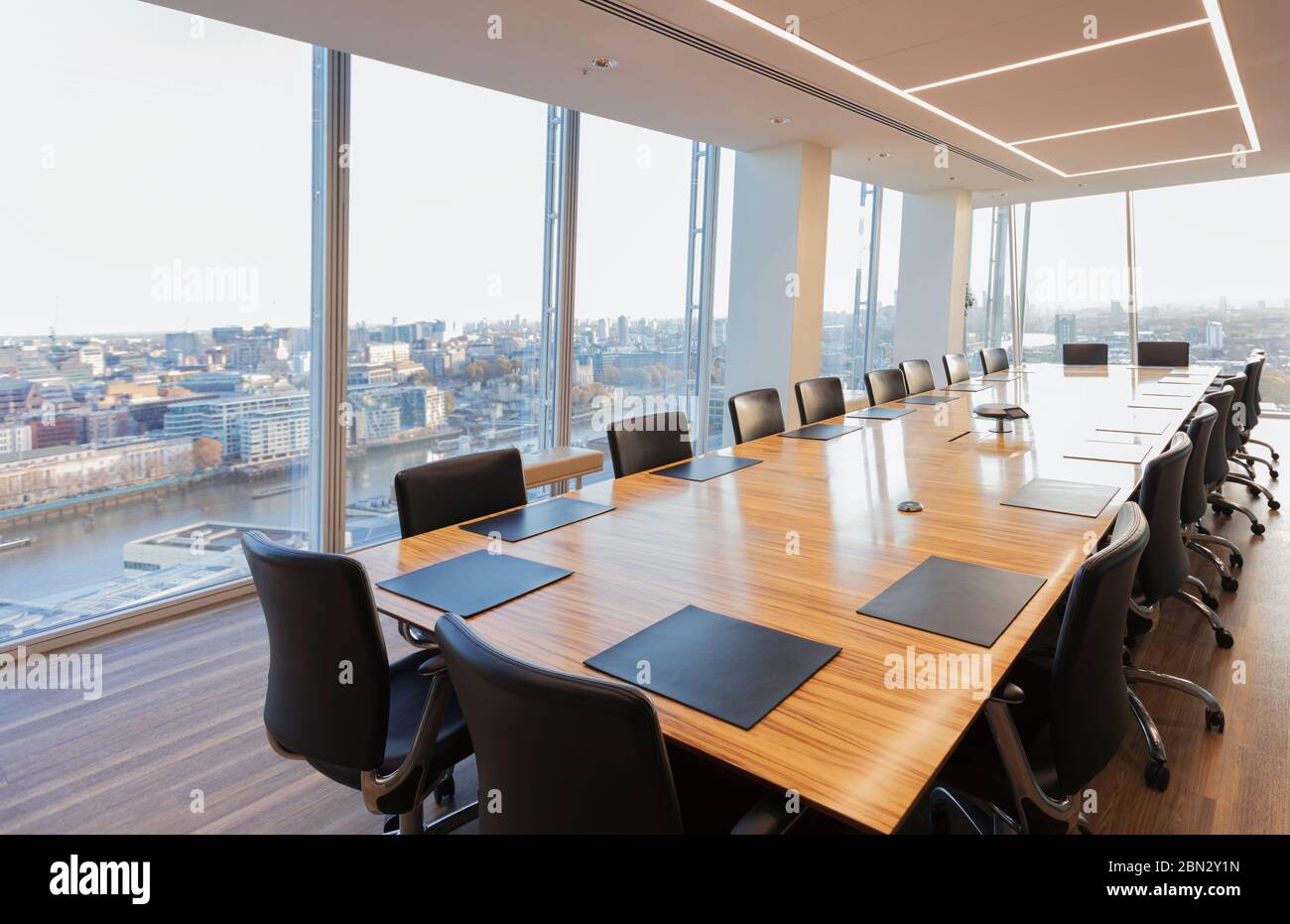 Long conference table in modern highrise office overlooking city Stock Photo