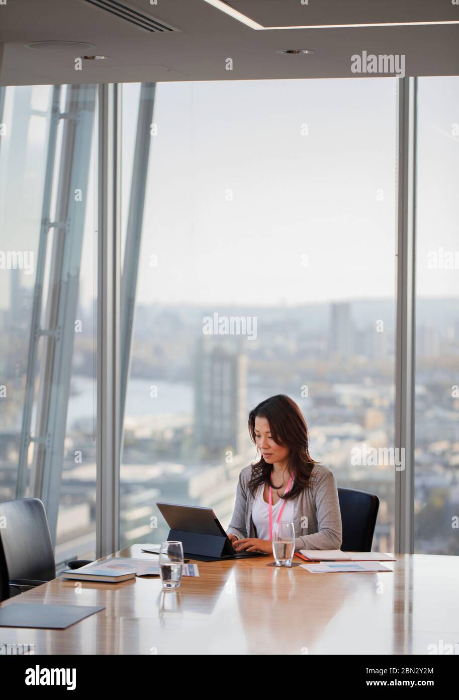 Businesswoman using digital tablet in urban highrise conference room Stock Photo