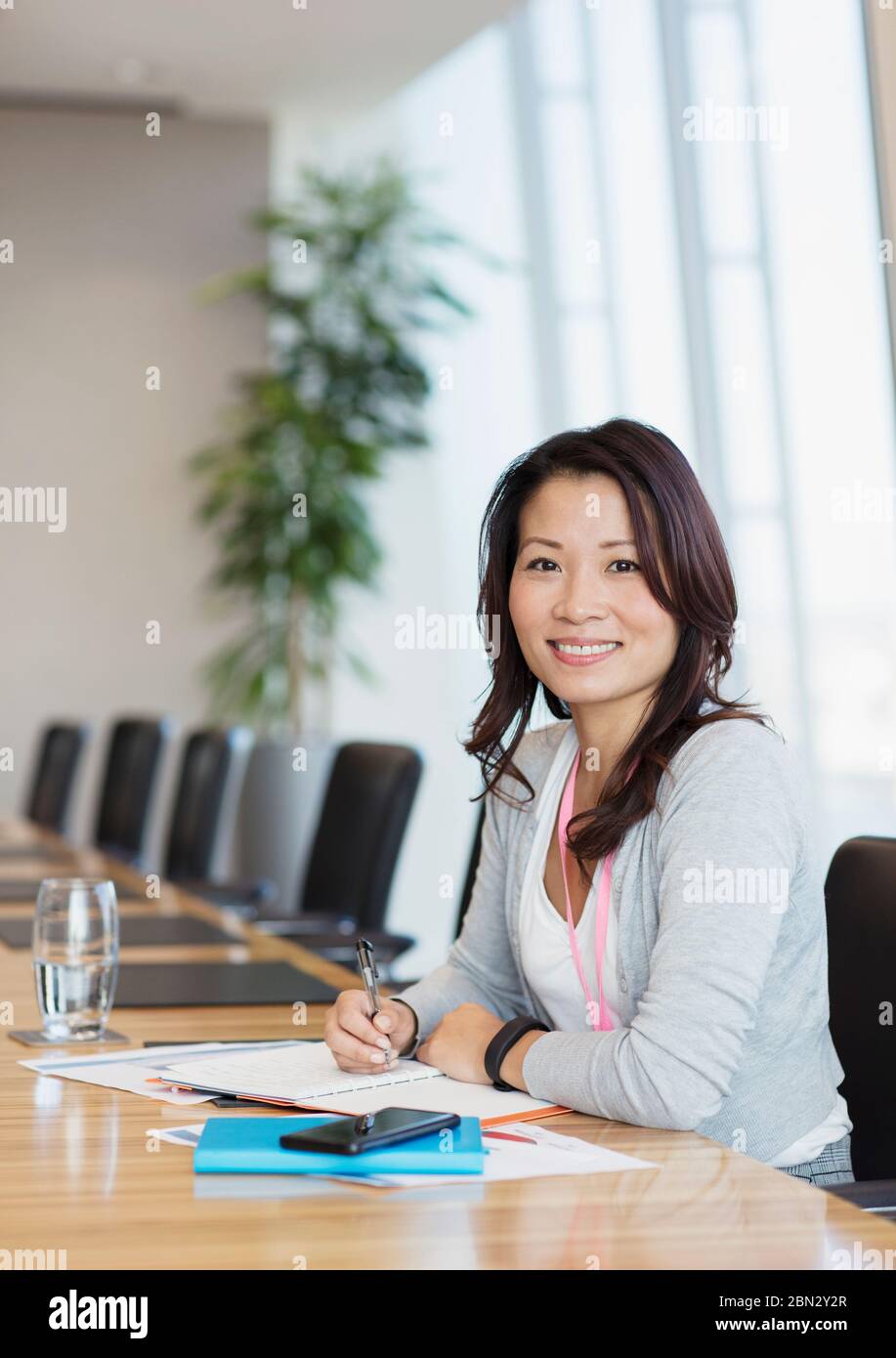 Portrait confident businesswoman working at conference table Stock Photo