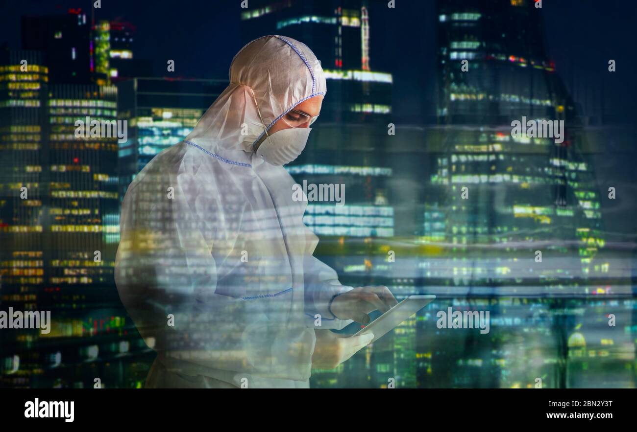 Male scientist in clean suit using digital tablet and working late Stock Photo