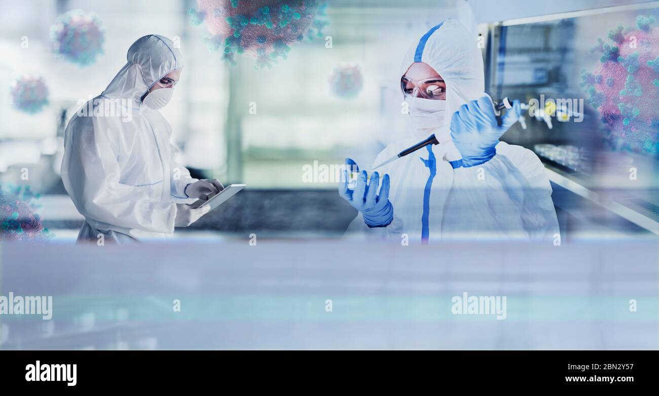 Scientists in clean suits studying coronavirus in laboratory Stock Photo