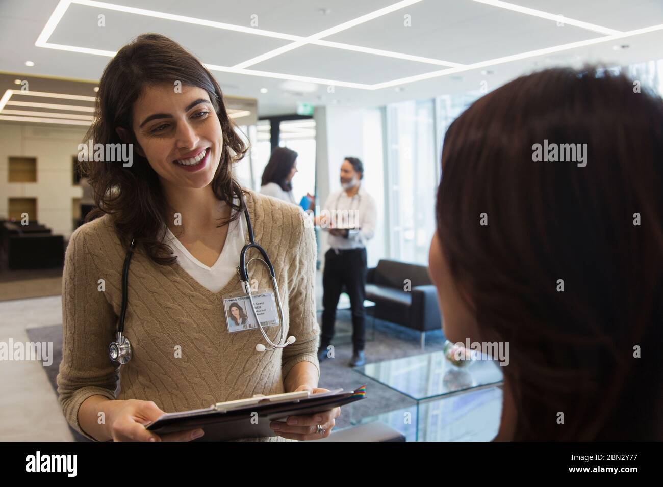 Smiling female doctor talking with colleague in office Stock Photo