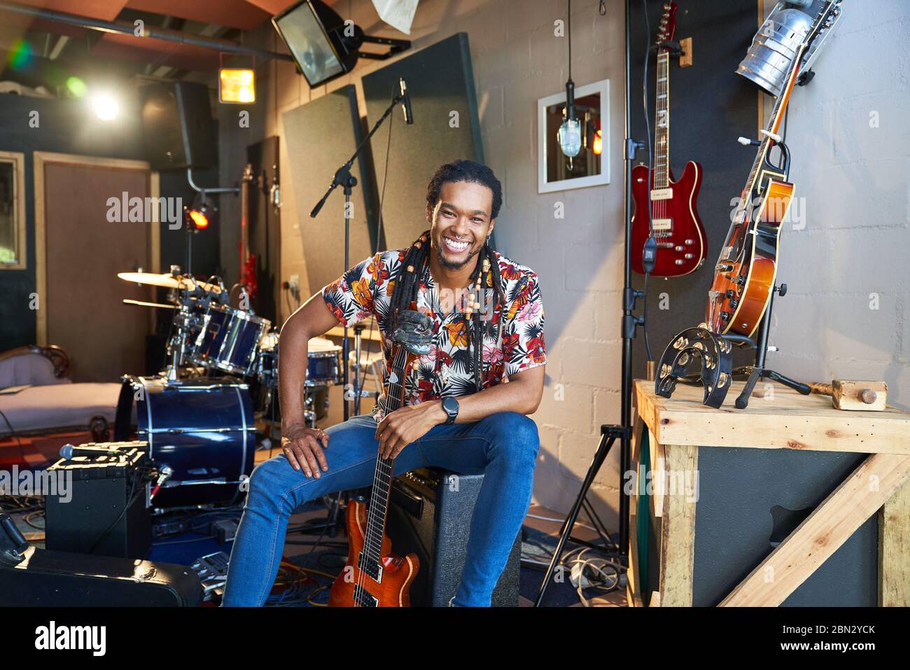 Portrait happy confident male musician with guitar in recording studio Stock Photo