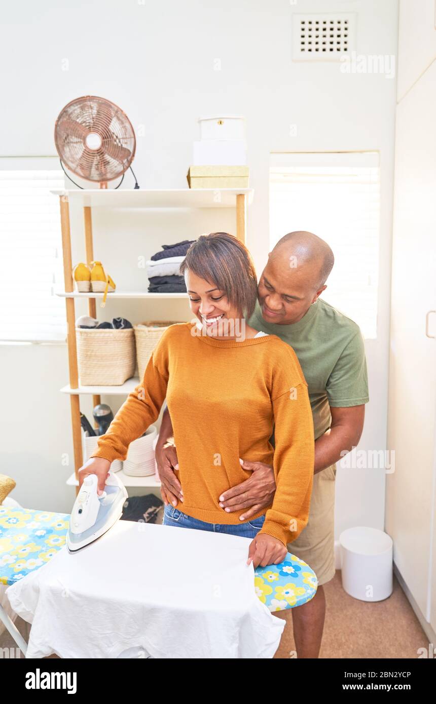 Happy couple ironing clothes at home Stock Photo
