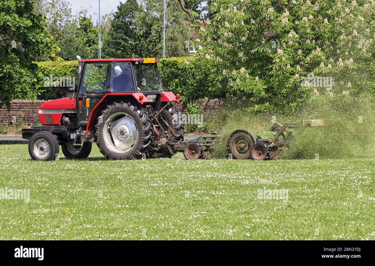 Tractor with trailer Mowing grass in a Public Park in England Stock Photo