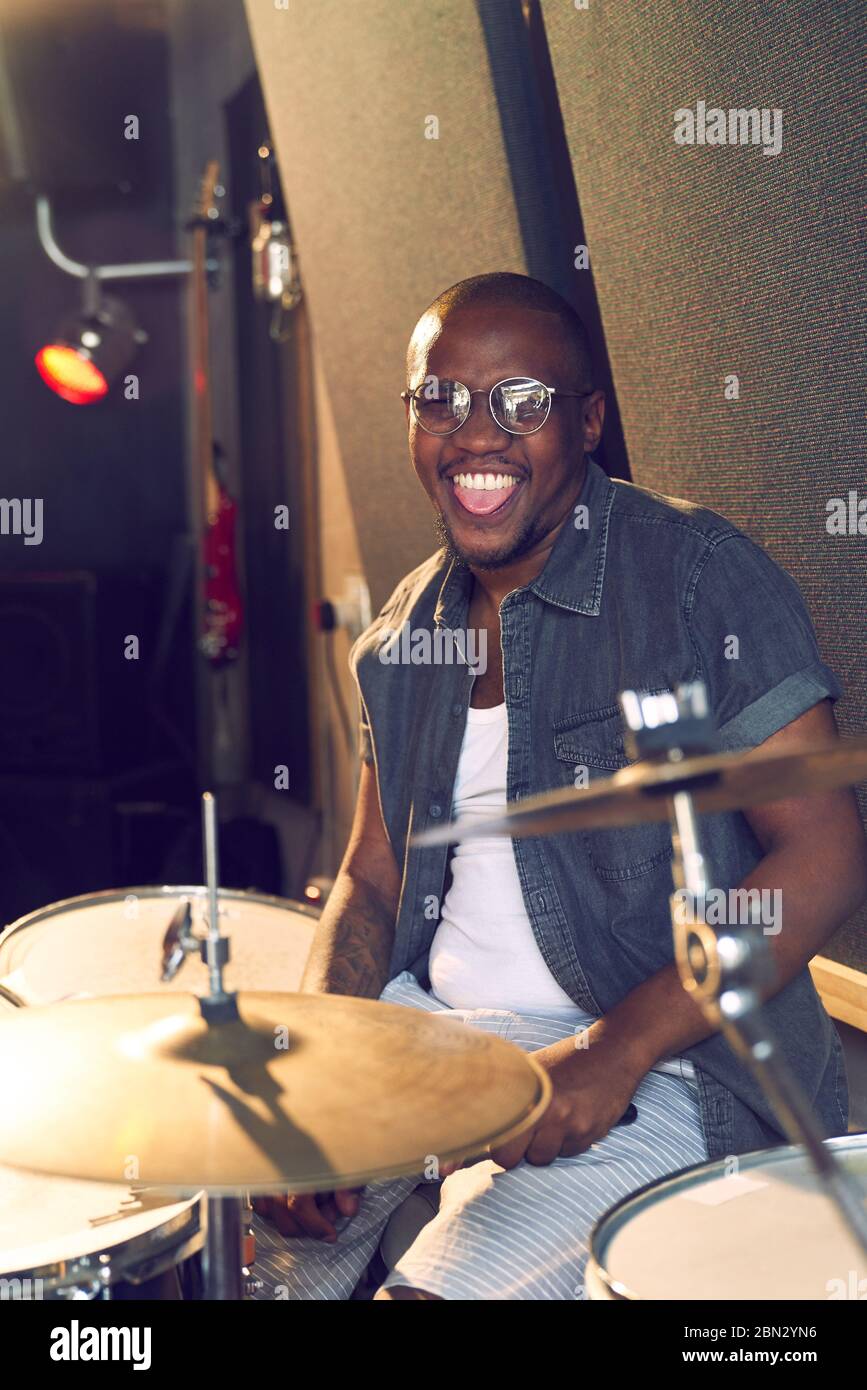 Portrait happy male drummer practicing at drums Stock Photo