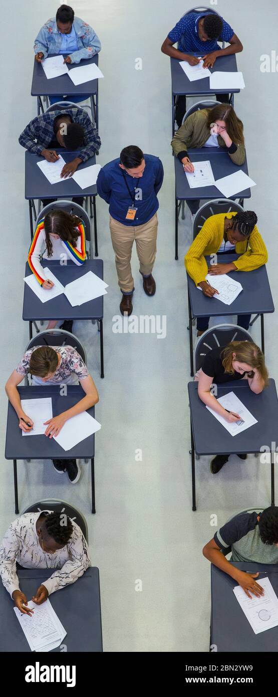 View from above high school teacher supervising students taking exam Stock Photo