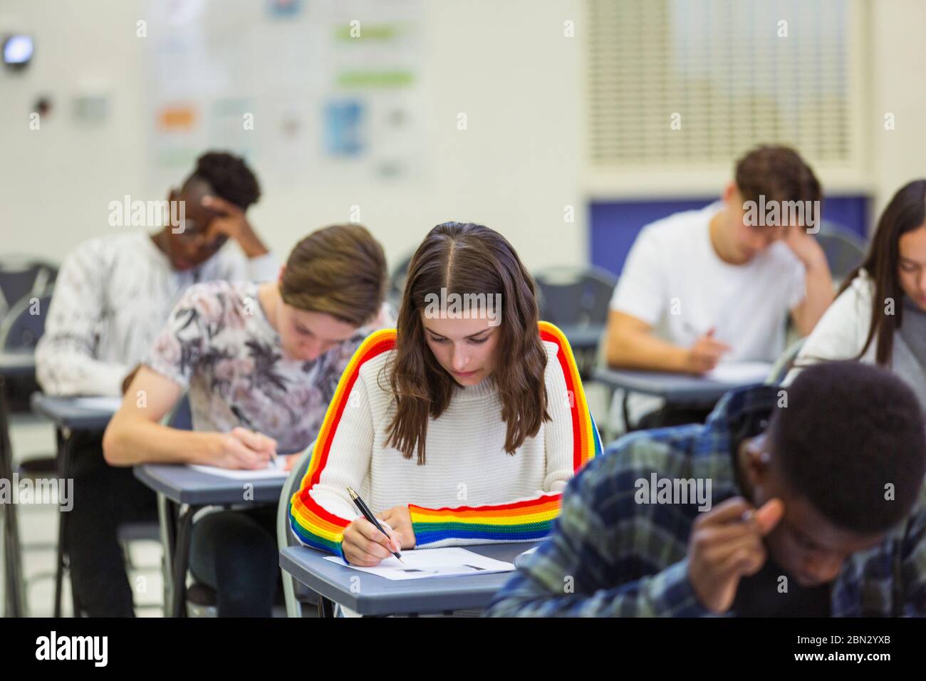 Focused high school girl student taking exam at desk in computer Stock Photo