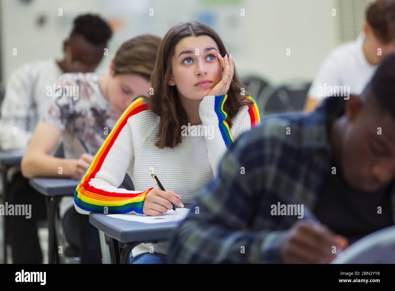 Focused high school girl student taking exam looking up Stock Photo
