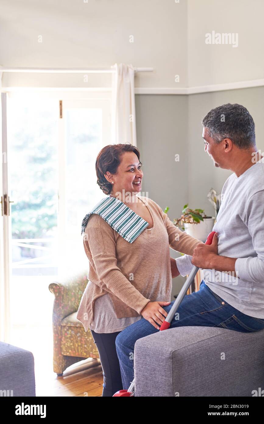 Mature couple talking and cleaning house Stock Photo