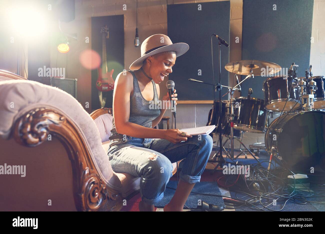 Young female musician singing and song writing in recording studio