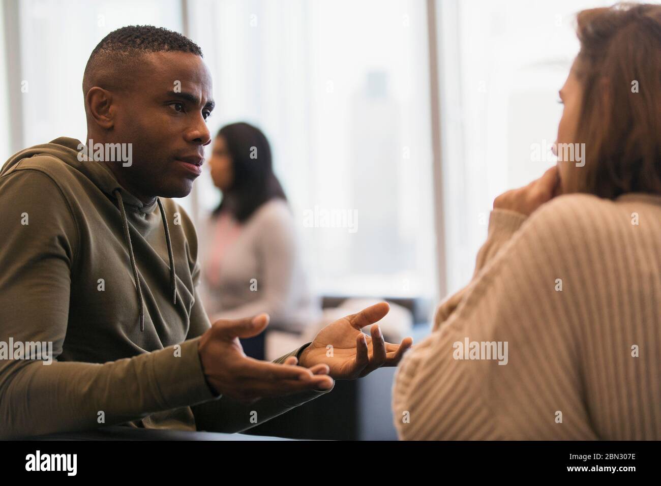 Businessman explaining to colleague in office Stock Photo