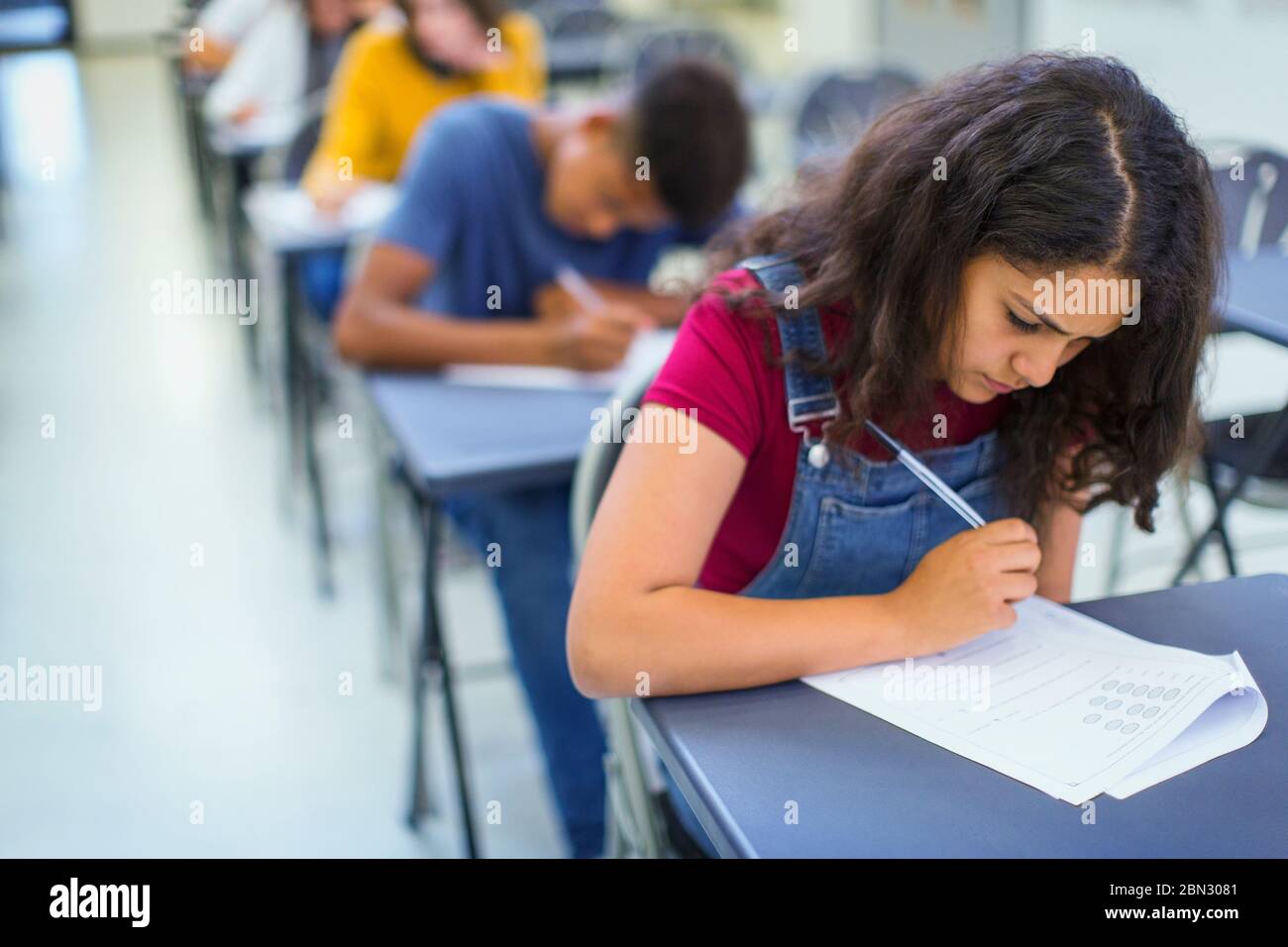 Focused high school girl student taking exam Stock Photo