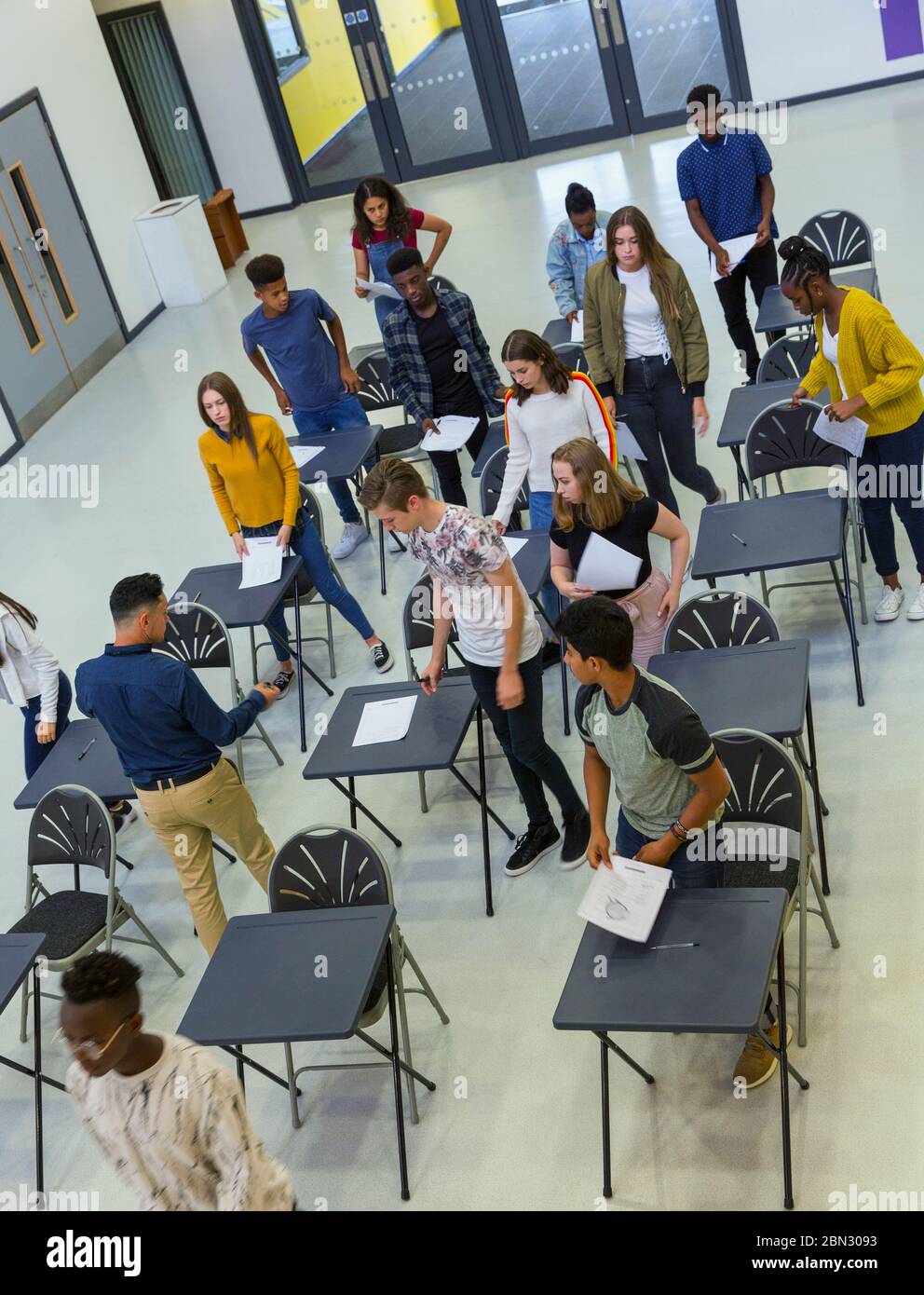 View from above high school students finishing exam at desks Stock Photo