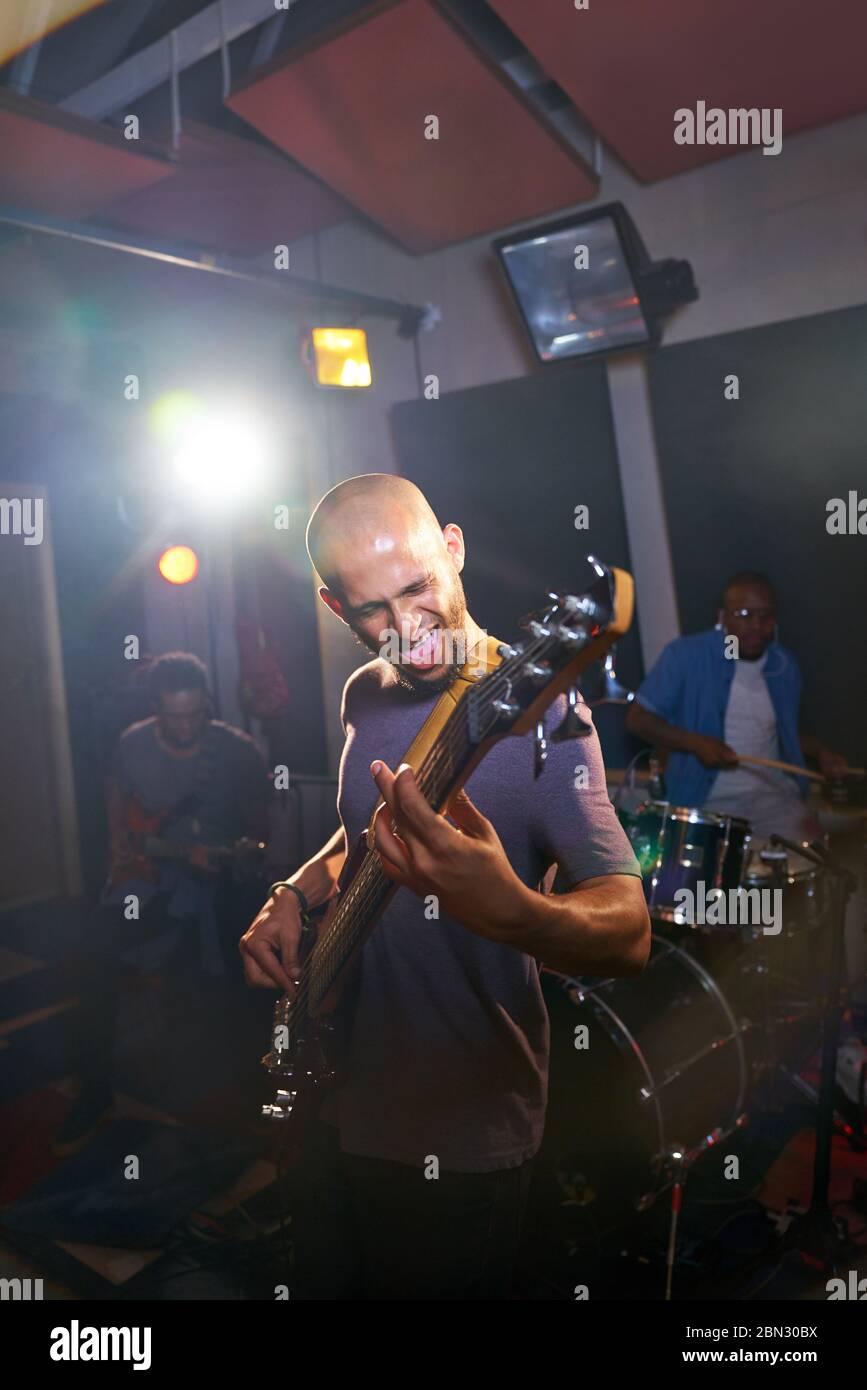 Male musician playing guitar in recording studio Stock Photo