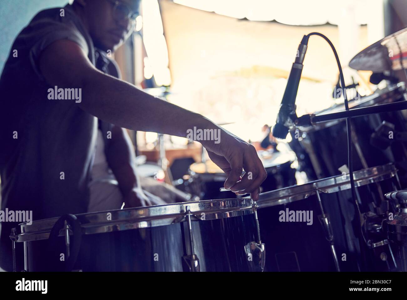 Male drummer adjusting drums in recording studio Stock Photo Alamy