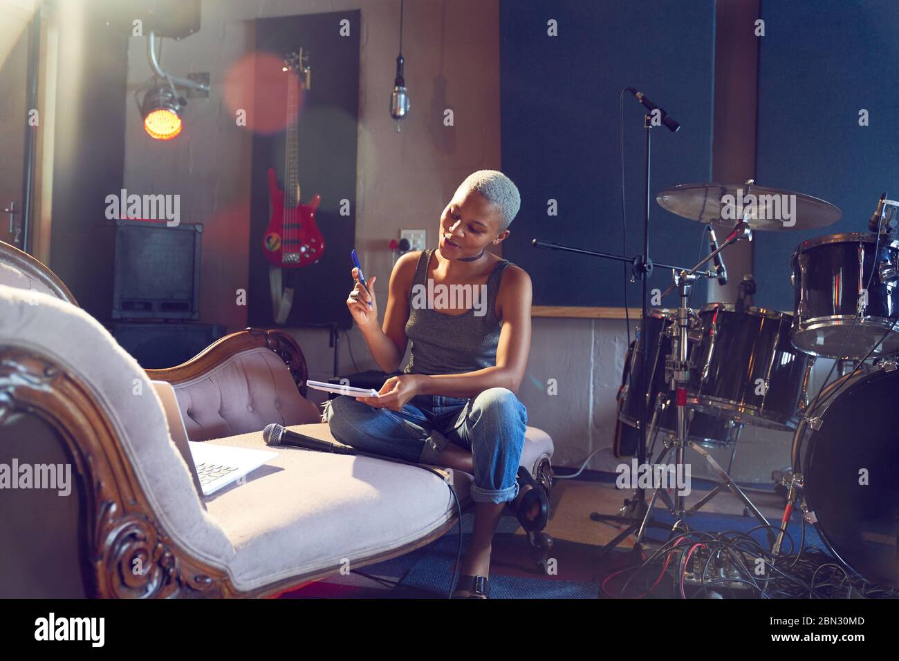 Young female musician song writing in recording studio Stock Photo