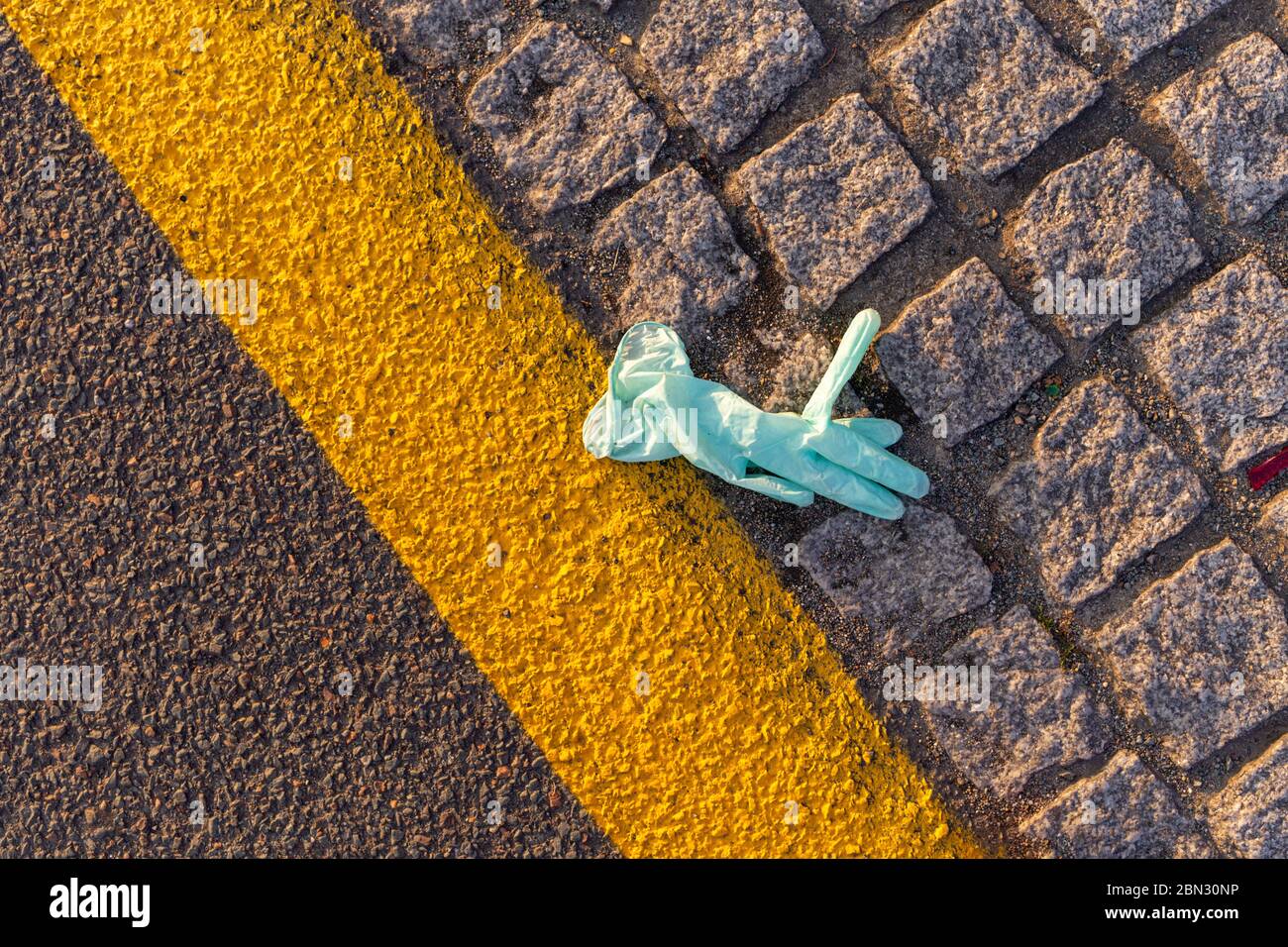 lost disposable gloves on graund, waste ppe on the street, enviromental Stock Photo