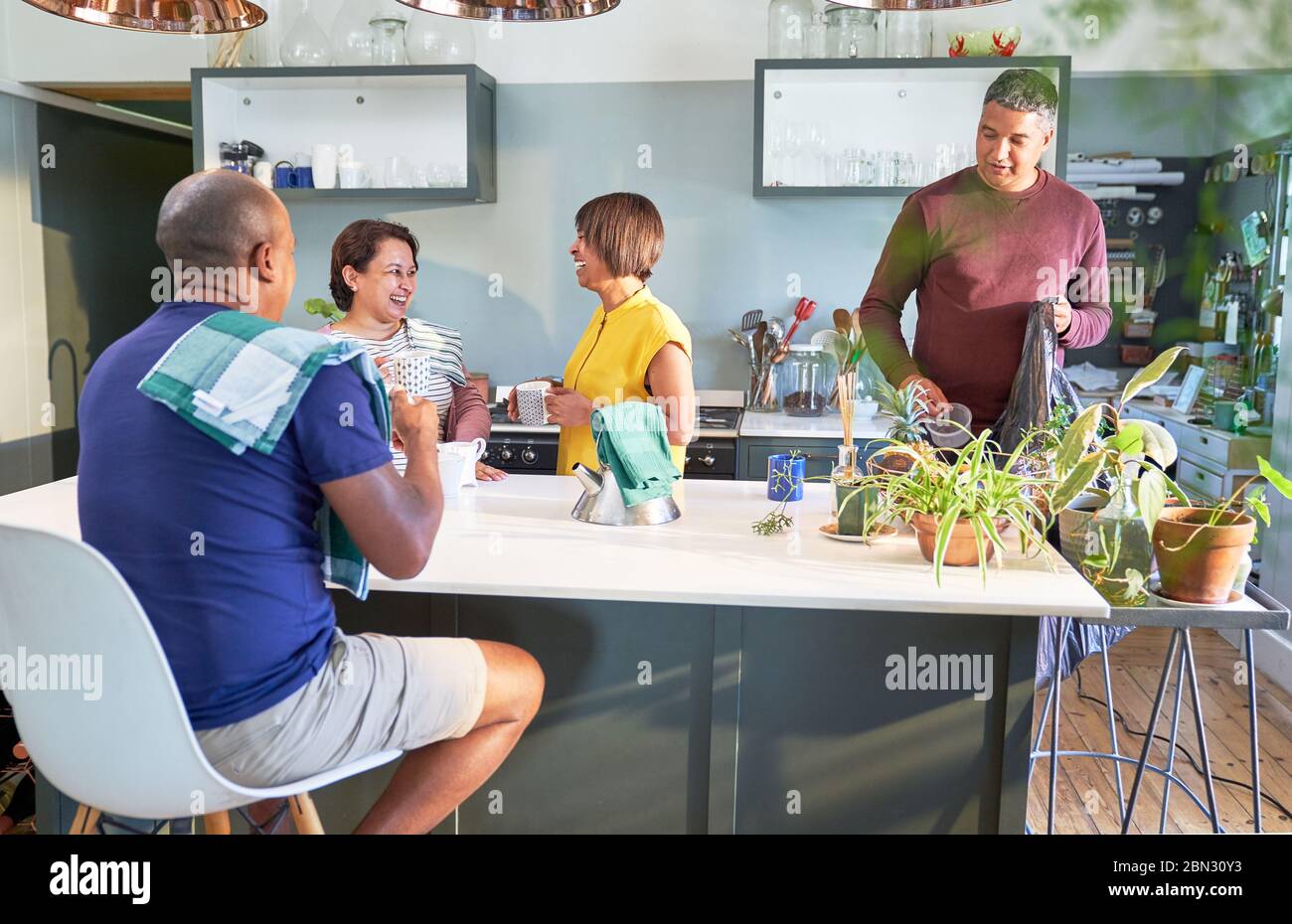 Mature couple friends talking and drinking tea in kitchen Stock Photo