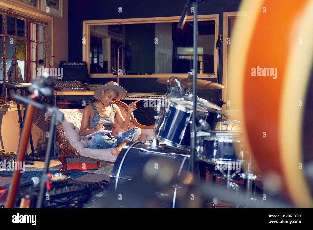 Female musician song writing in recording studio Stock Photo