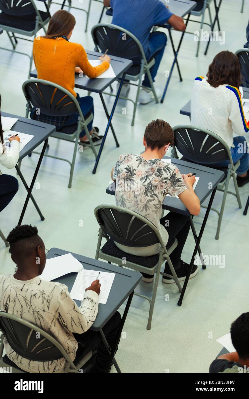 High school students taking exam at desks in classroom Stock Photo