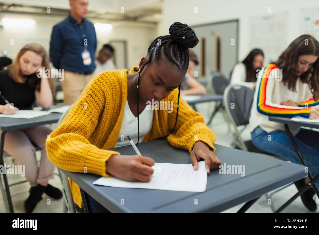 Focused high school girl student taking exam at desk Stock Photo