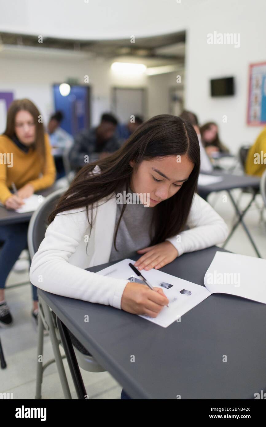 High school girl taking exam at desk in classroom Stock Photo