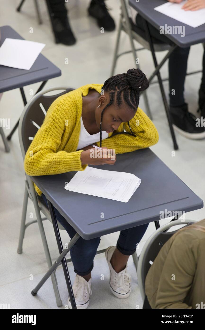 Focused high school girl student taking exam at desk in classroom Stock Photo