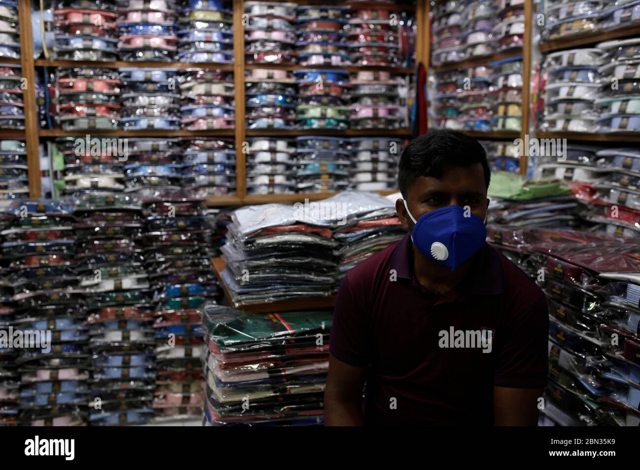 Dhaka, Bangladesh. 12th May, 2020. A clothing store owner wears a face mask  as waits for