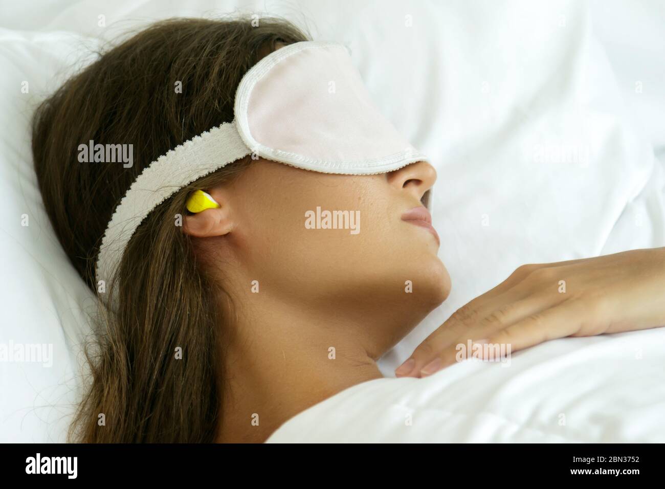 Woman is wearing eye mask and using earplugs for better sleeping