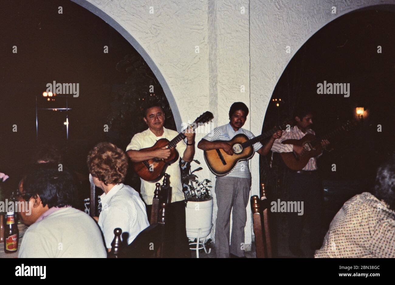 Men playing guitar for customers during supper at Hotel Bolivar in Honduras ca. 1987 Stock Photo