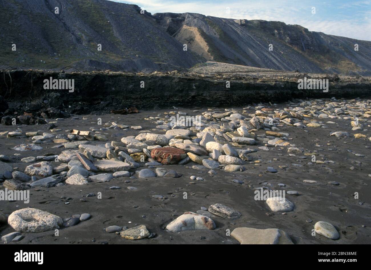 Sea erosion of coal waste on beach below disused mine Seaham Co Durham UK Stock Photo