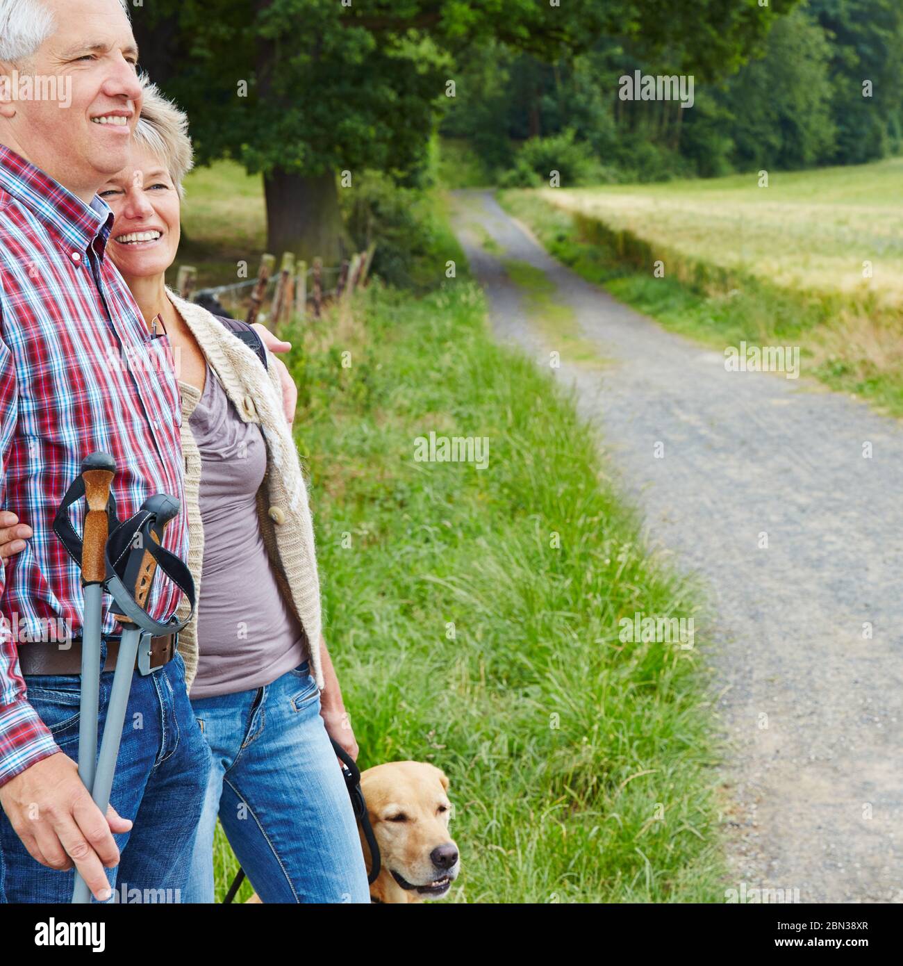 Two happy seniors with dog hiking in the forest Stock Photo