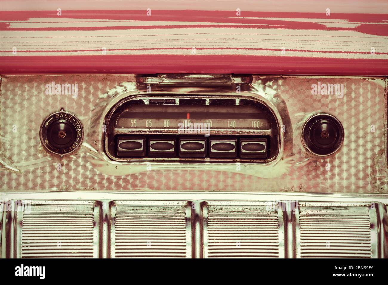 Retro styled image of an old car radio inside a pink classic car Stock Photo