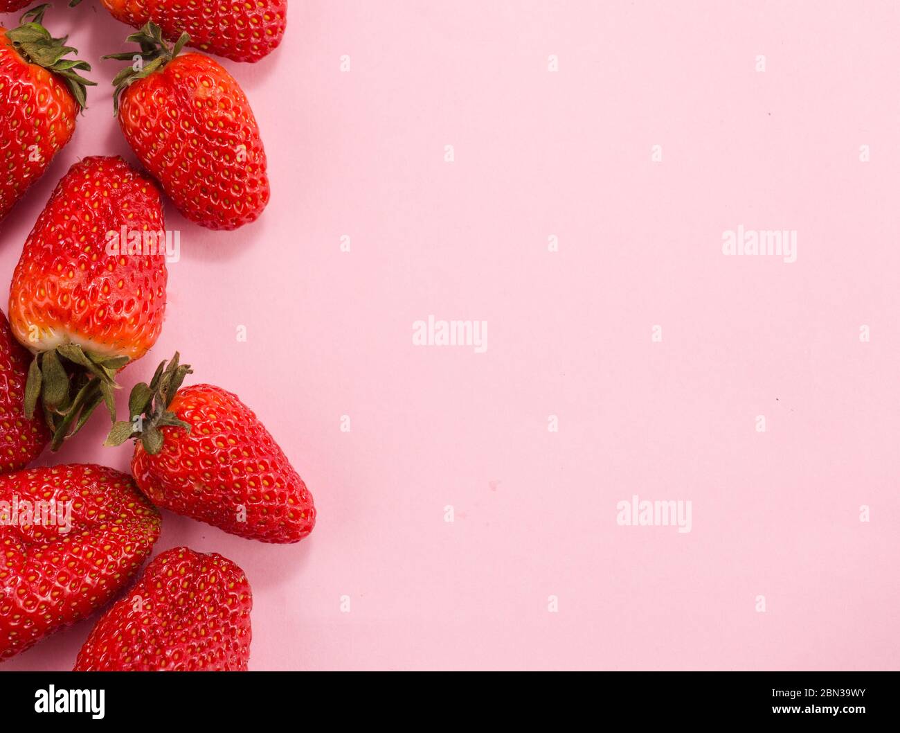 Fresh natural strawberries in white bowl on soft pink background with ...
