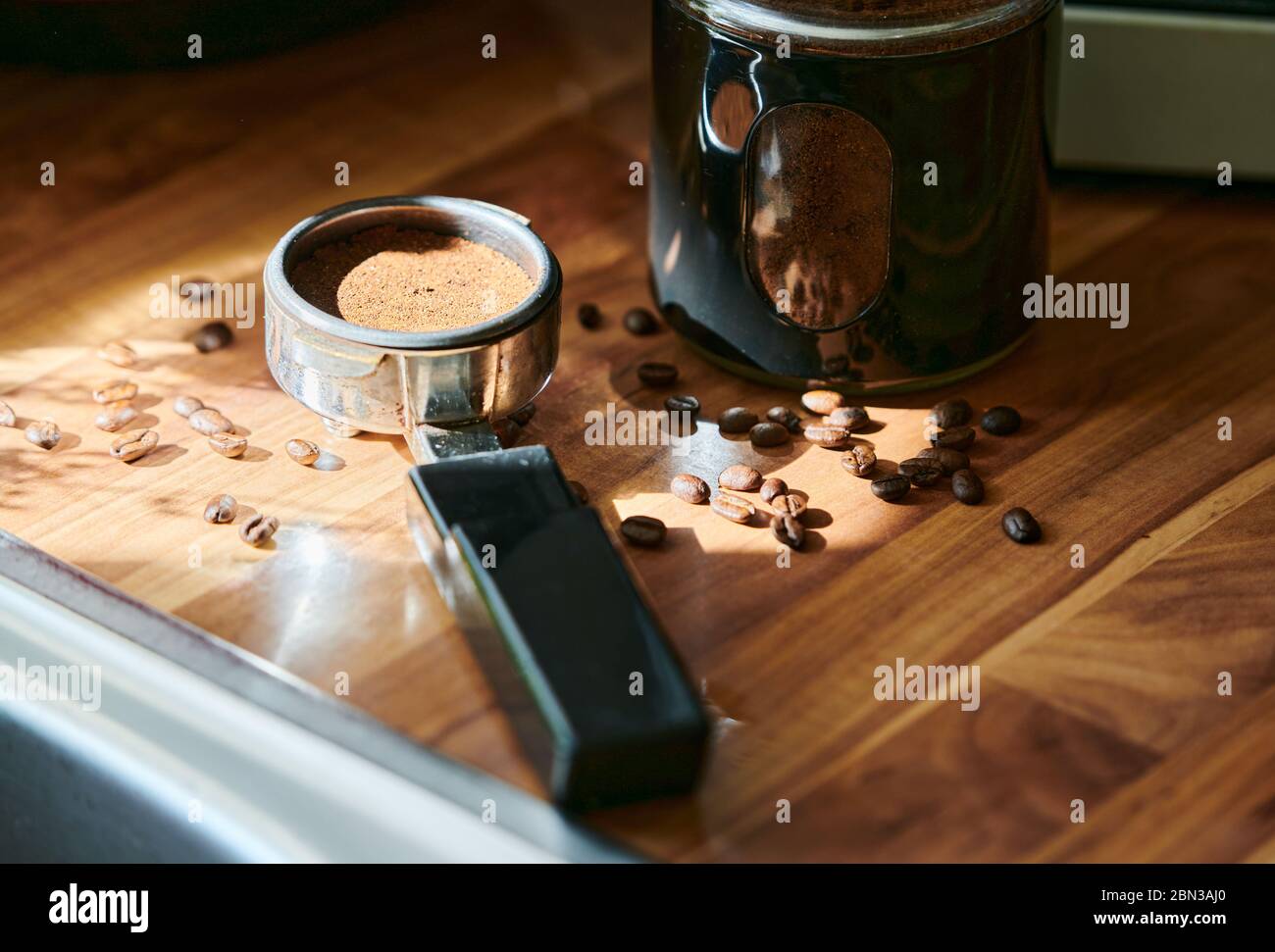 Coffee powder in the measuring cup to make espresso at home with coffee beans in the background. Stock Photo