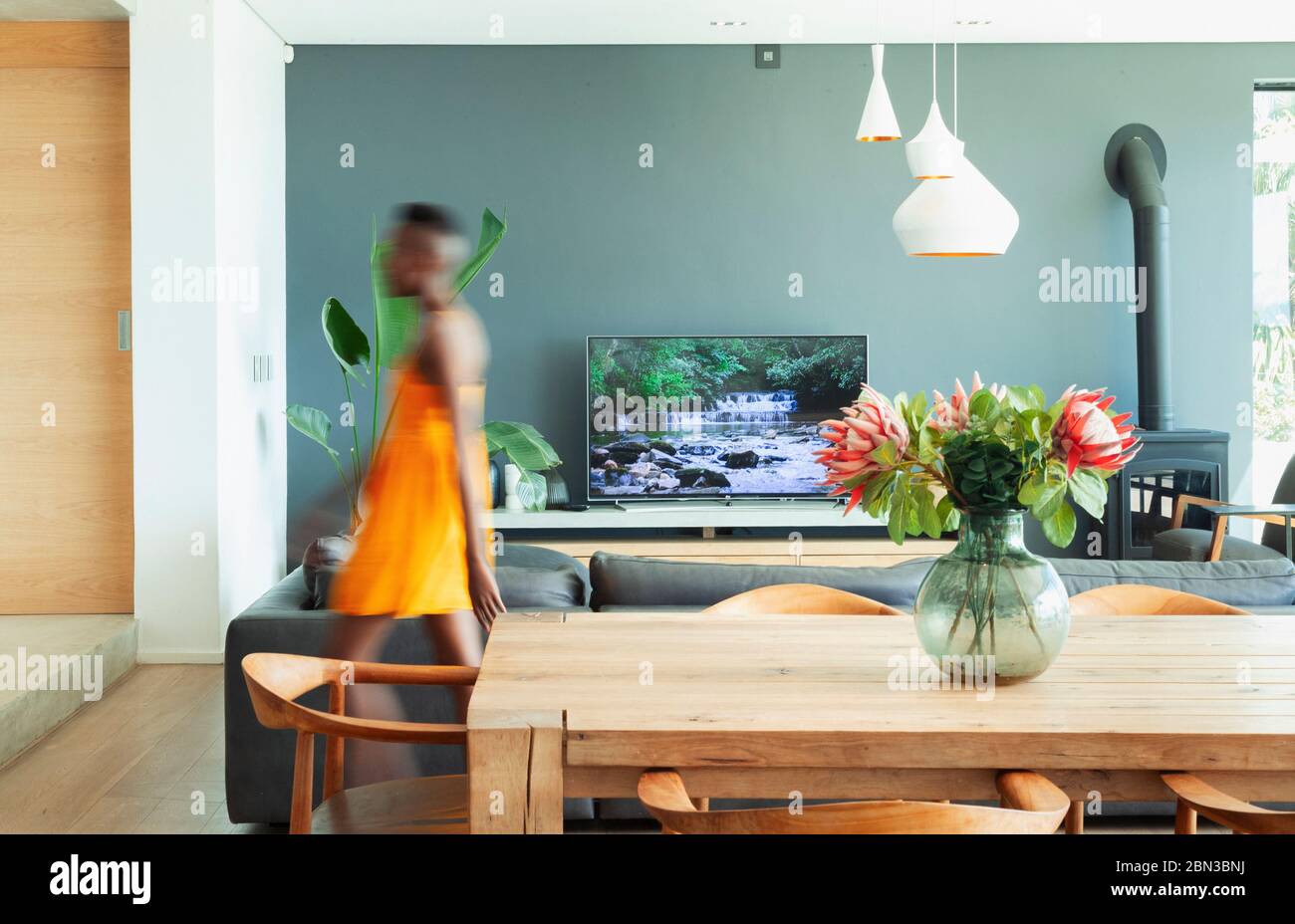 Young woman walking in modern dining room Stock Photo