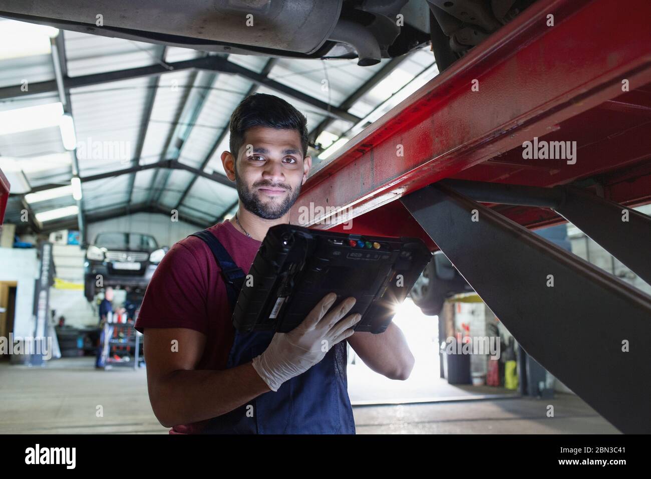 Portrait confident male mechanic with diagnostic equipment in auto repair shop Stock Photo