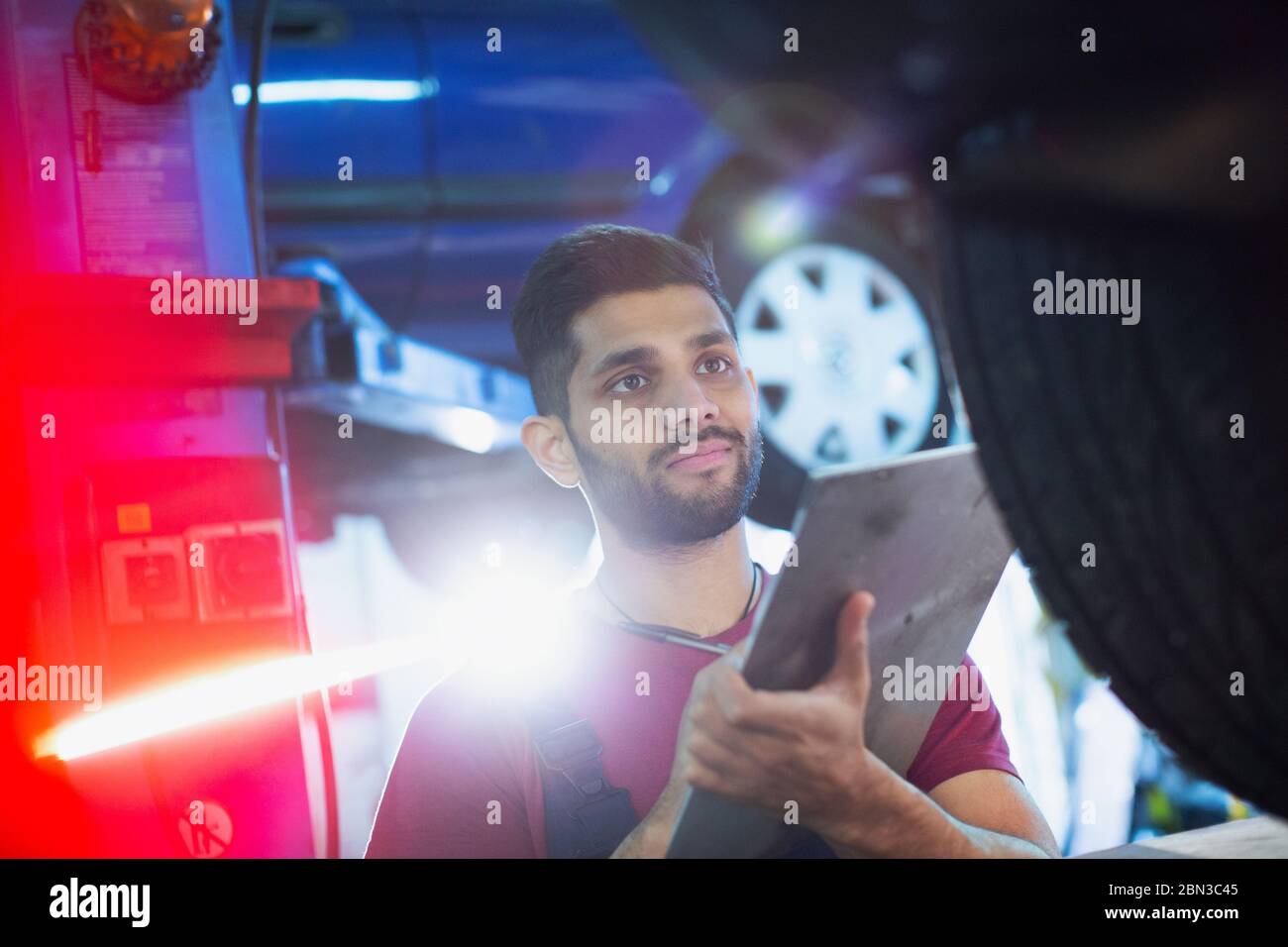 Male mechanic with clipboard working in auto repair shop Stock Photo