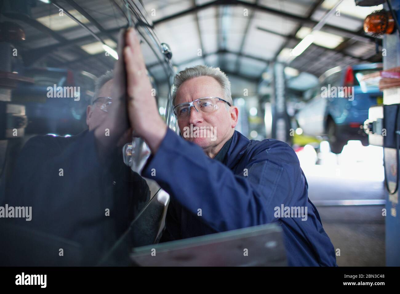 Male mechanic examining car in auto repair shop Stock Photo