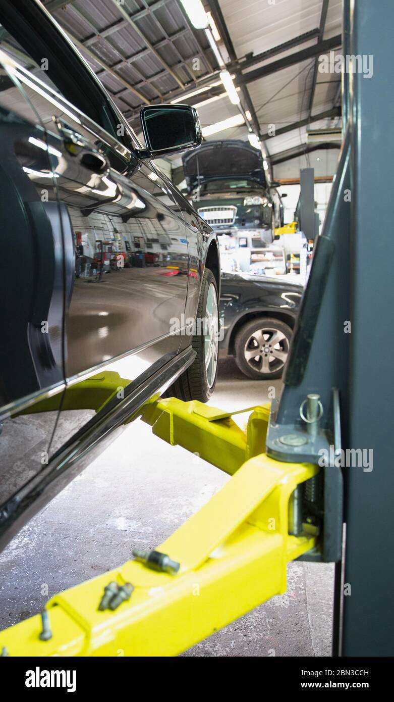 Car on hydraulic lift in auto repair shop Stock Photo