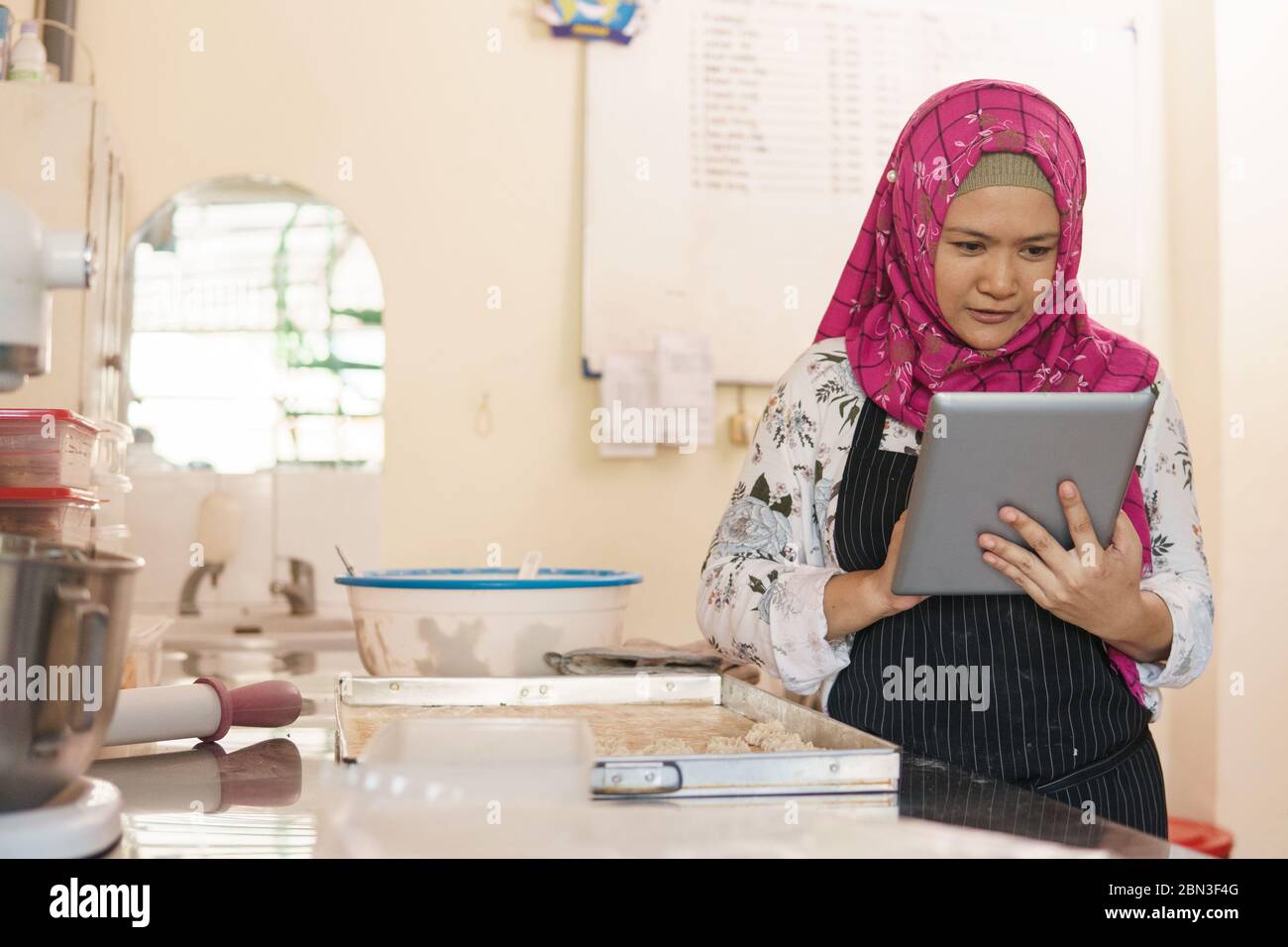 busy bakery owner preparing some order using tablet pc Stock Photo