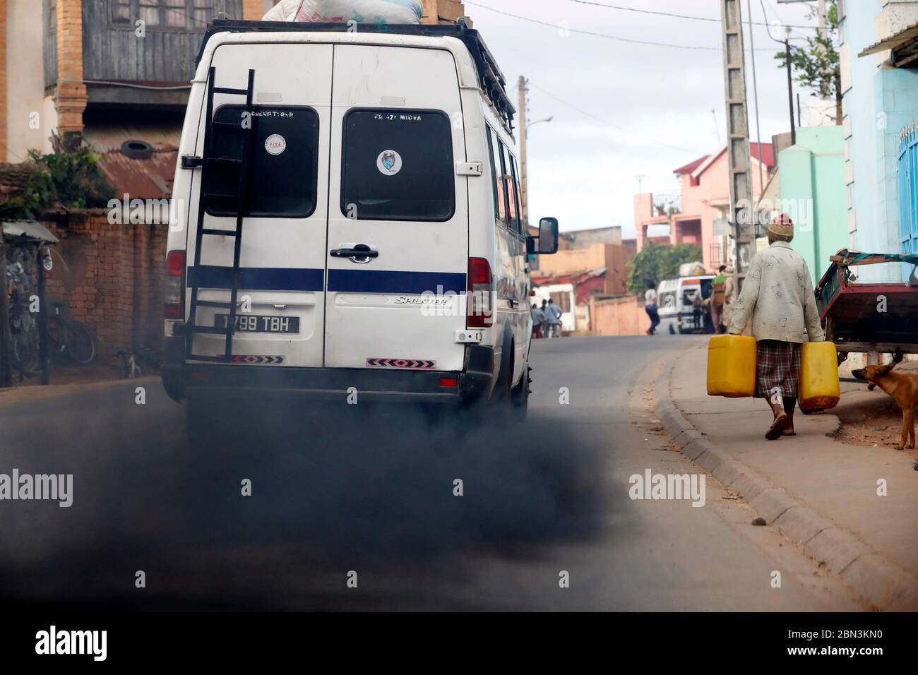 Old minibus emitting black smoke on road. Pollution.  Antananarivo. Madagascar. Stock Photo